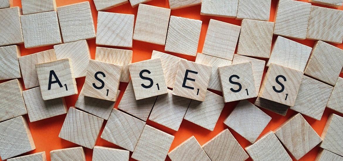 Scrabble tiles spelling "ASSESS"