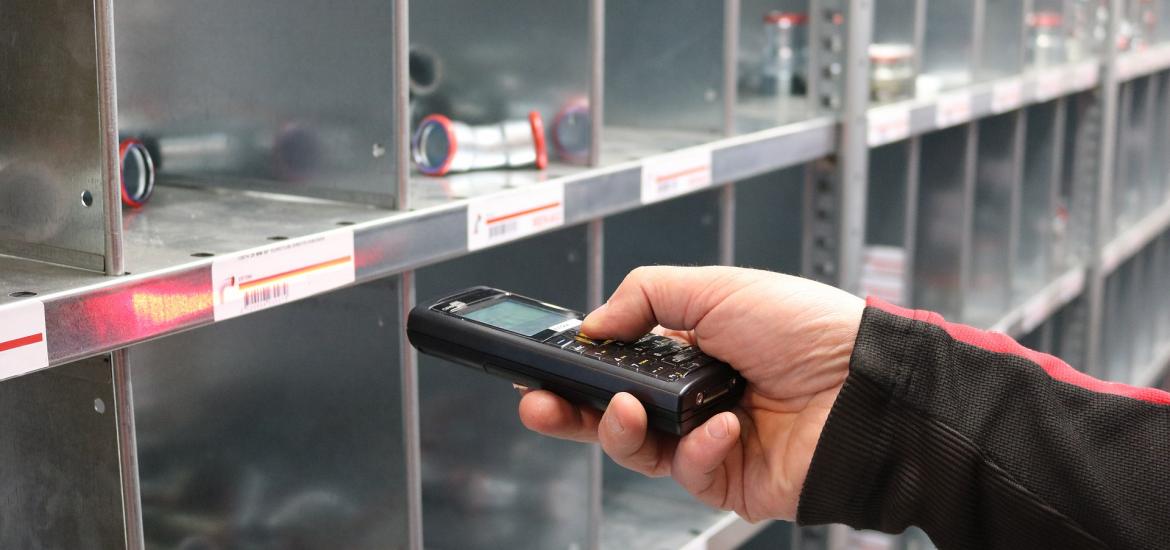 someone scanning a warehouse bin with parts