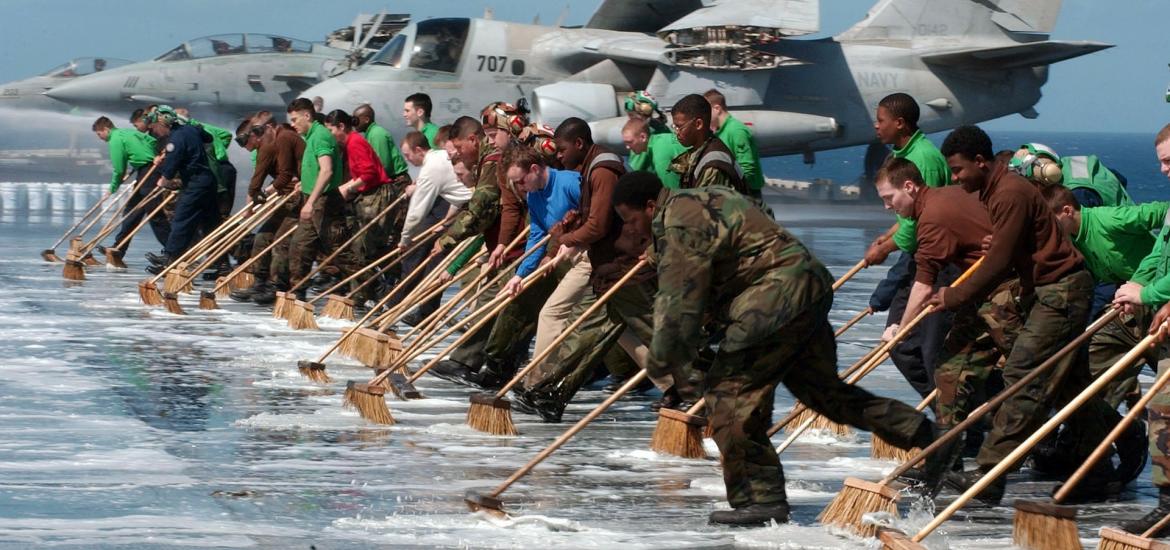 men on a boat, sweeping